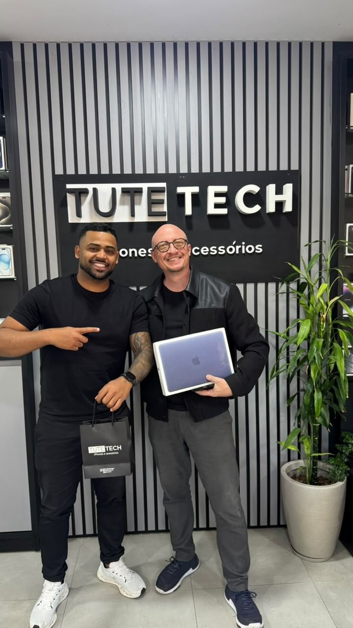 Cliente com a caixa do MacBook novo, ao lado do consultor