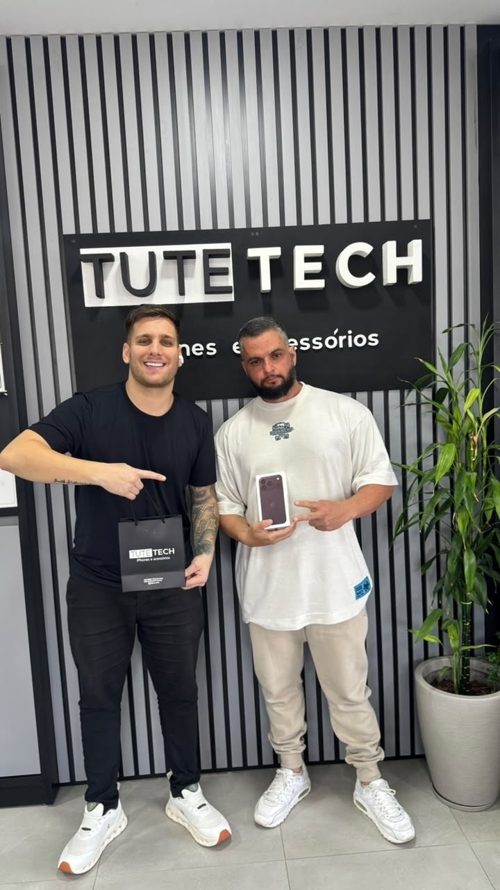 Cliente segura a caixa do iPhone novo, ao lado do consultor