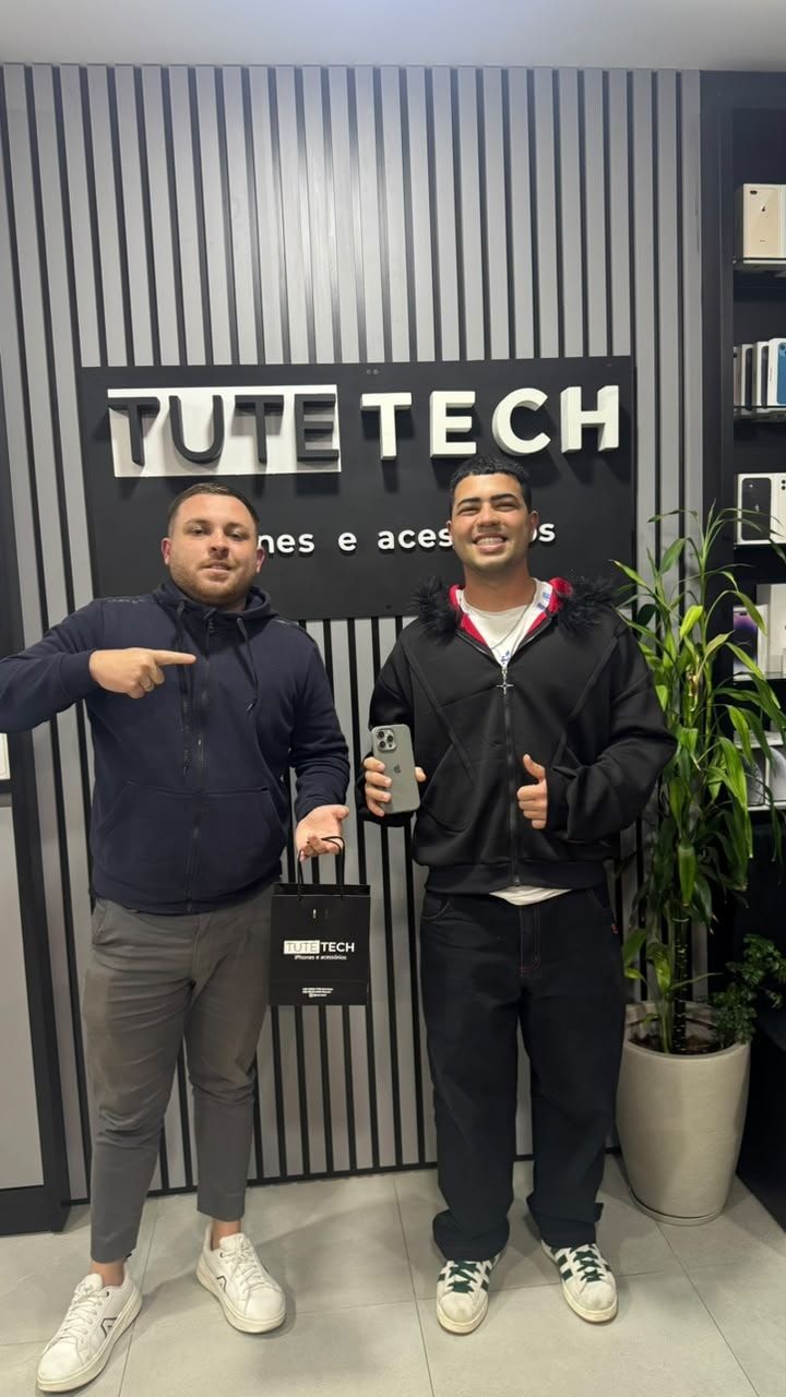 Cliente com a sacola da loja e o iPhone novo, ao lado do consultor