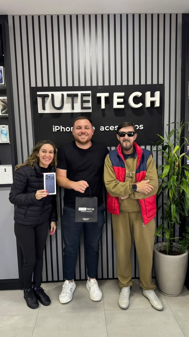 Clientes com a caixa do iPhone novo, em frente ao painel da Tute Tech