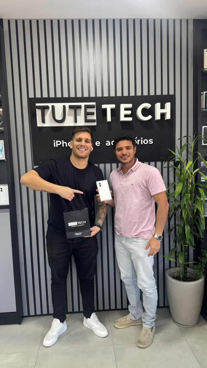 Cliente de camisa rosa com o iPhone novo, ao lado do consultor