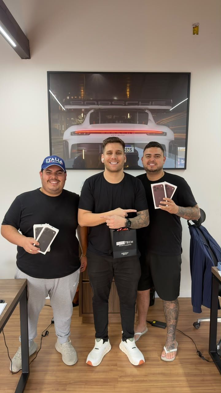 Clientes mostram as caixas dos iPhones novos ao lado do consultor