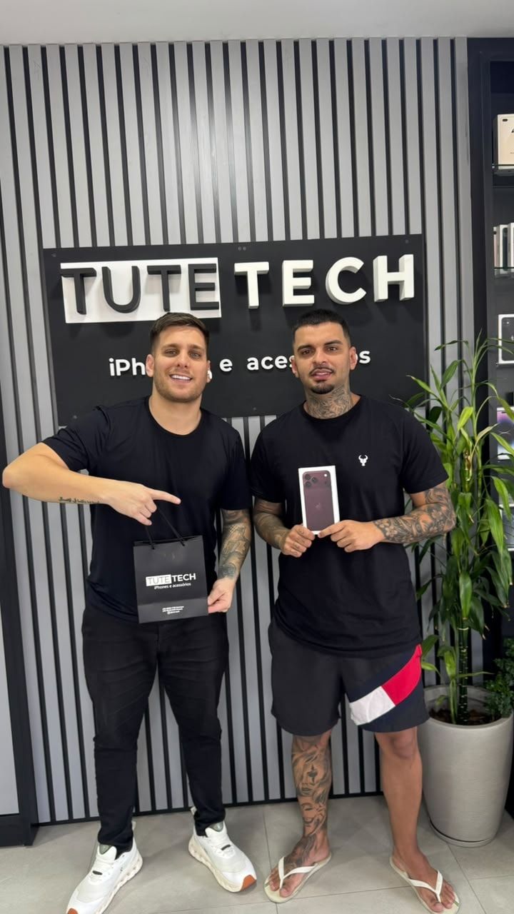 Cliente segura a caixa do iPhone novo ao lado do consultor