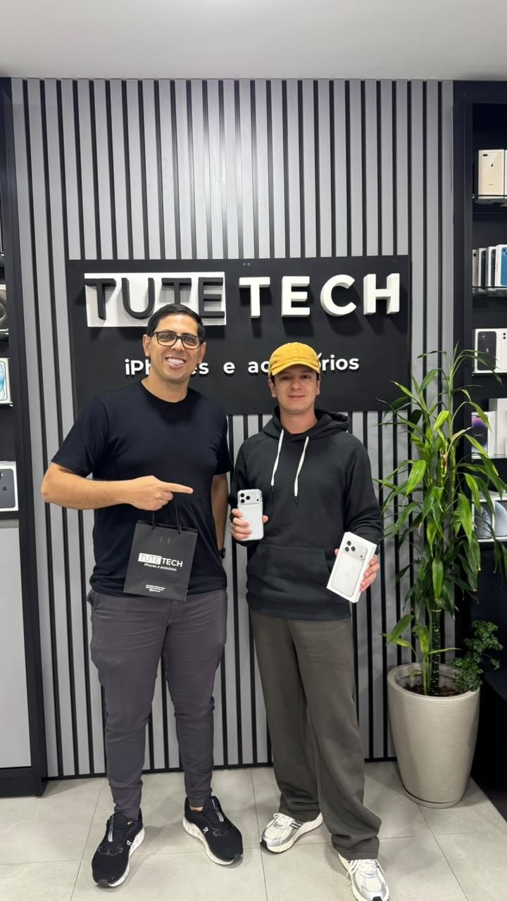 Cliente de boné com a caixa do iPhone novo, ao lado do consultor
