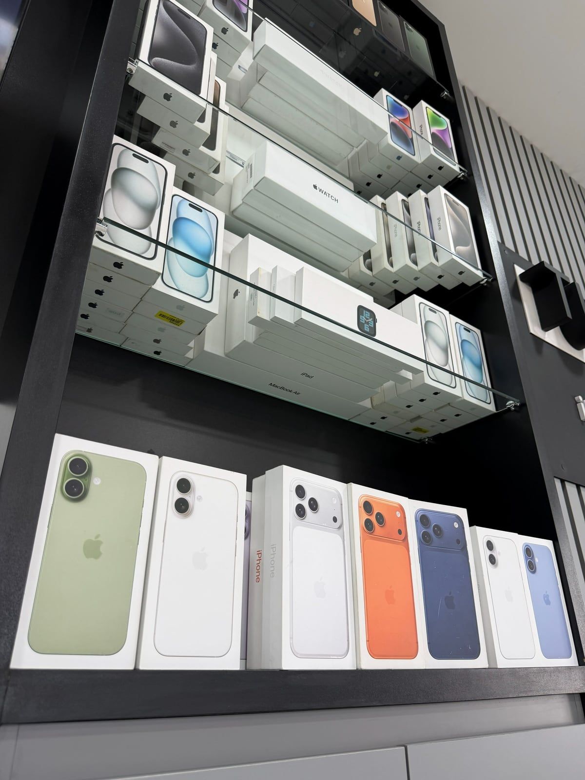 Prateleira com caixas de iPhones novos em várias cores
